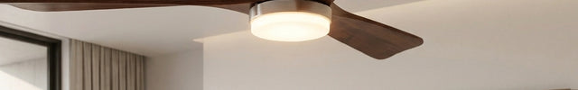 Détail du moyeu argenté et du disque LED allumé du ventilateur de plafond à pales en bois massif de noyer