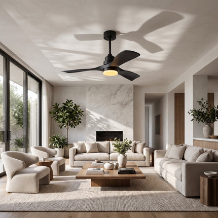 Ventilateur de plafond noir mat allumé dans un salon clair aux murs blancs et cheminée en marbre