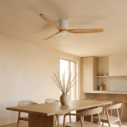 Ventilateur de plafond bas en bois clair et blanc au plafond d'une salle à manger ouverte sur la cuisine