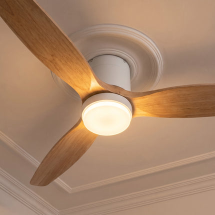 Ventilateur de plafond bas LED bois clair vu en contre-plongée, lumière chaude allumée