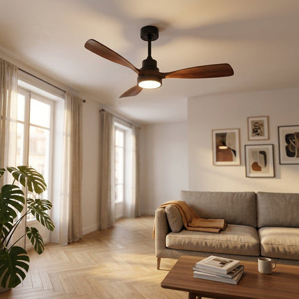 Ventilateur de plafond bois et noir dans un salon lumineux avec canapé en lin
